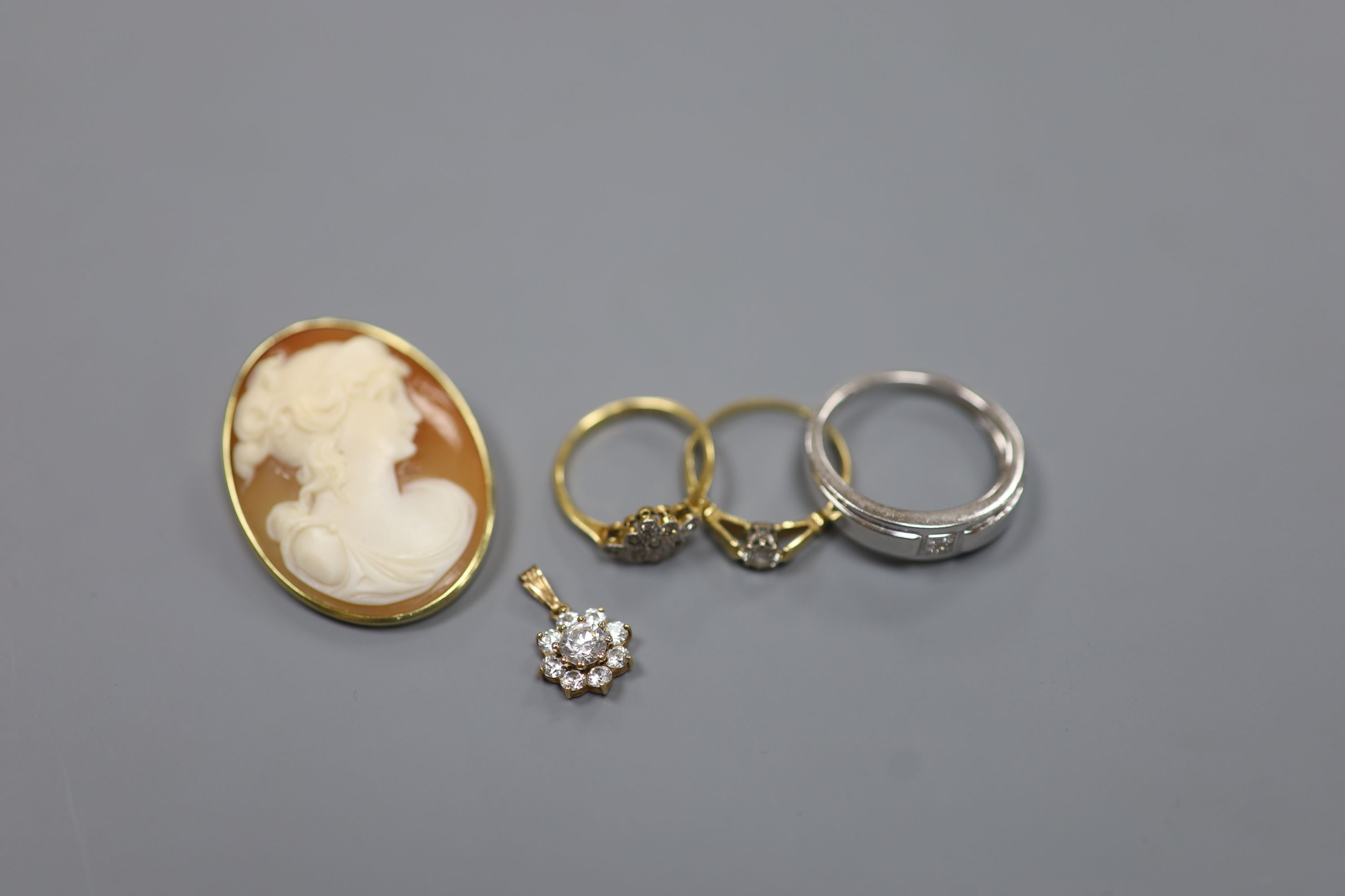 A modern 9ct white gold and diamond ring and a 9ct pendant, gross 4.7 grams, two 18ct and diamond rings, gross 3.6 grams and a yellow metal mounted cameo shell brooch, gross 9.5 grams.